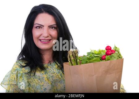 Bonne femme tenant un sac de shopping avec des aliments isolés sur fond blanc Banque D'Images