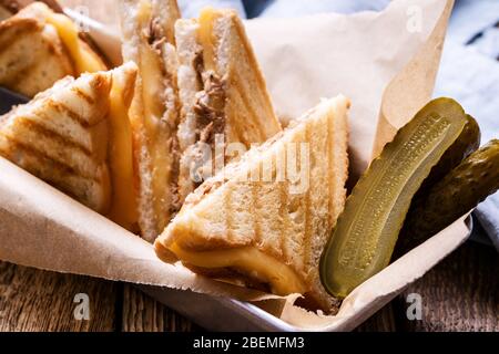 Sandwichs au thon maison avec fromage servis avec des cornichons sur une table en bois rustique Banque D'Images