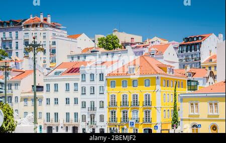 Portugal, Lisbonne en été, rue de Lisbonne, belle maison jaune parmi les maisons blanches à Lisbonne, balcons forgés sur le mur jaune, statue du Lion dans Banque D'Images