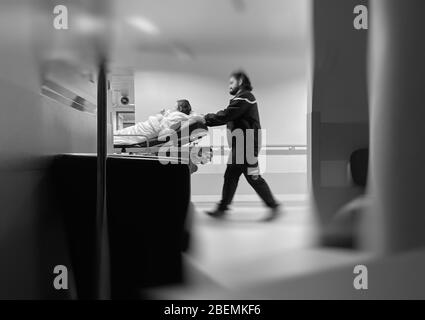 Flou flou flou flou image conceptuelle de patient non reconnaissable sur le lit de paroisse transporté avec urgence dans le couloir hospitalier pendant le covid contagieux de coronavirus 19. Banque D'Images