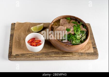Soupe vietnamienne traditionnelle Pho bo aux herbes, bœuf, nouilles de riz, bouillon, chaux. Vue de dessus Banque D'Images