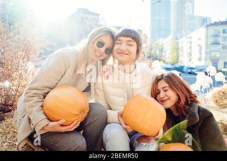 Les filles tient les citrouilles dans les mains sur le fond de la rue. Banque D'Images