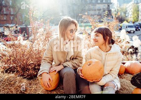 Les filles tient les citrouilles dans les mains sur le fond de la rue. Banque D'Images