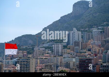 Drapeau monégasque avec bâtiments résidentiels en arrière-plan à Monte Carlos, Monaco, Europe Banque D'Images