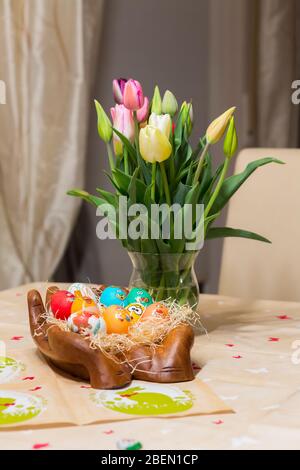 Vacances de Pâques avec des œufs et des fleurs de couleur. Tulipes colorées près des oeufs de Pâques peints de différentes couleurs Banque D'Images