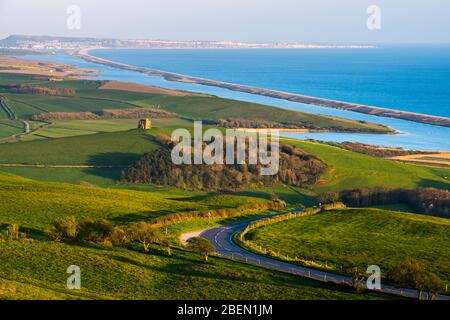 Abbotsbury, Dorset, Royaume-Uni. 14 avril 2020. Météo britannique. Vue sur la chapelle Sainte-Catherine et le lagon de Fleet depuis le sentier de sentier South Dorset Ridgeway à Abbotsbury, dans le Dorset, lors d'une soirée chaude et ensoleillée pendant le verrouillage de la pandémie de coronavirus. La route côtière B3157 est également illustrée. Crédit photo : Graham Hunt/Alay Live News Banque D'Images