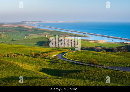 Abbotsbury, Dorset, Royaume-Uni. 14 avril 2020. Météo britannique. Vue sur la chapelle Sainte-Catherine et le lagon de Fleet depuis le sentier de sentier South Dorset Ridgeway à Abbotsbury, dans le Dorset, lors d'une soirée chaude et ensoleillée pendant le verrouillage de la pandémie de coronavirus. La route côtière B3157 est également illustrée. Crédit photo : Graham Hunt/Alay Live News Banque D'Images