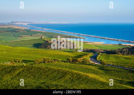 Abbotsbury, Dorset, Royaume-Uni. 14 avril 2020. Météo britannique. Vue sur la chapelle Sainte-Catherine et le lagon de Fleet depuis le sentier de sentier South Dorset Ridgeway à Abbotsbury, dans le Dorset, lors d'une soirée chaude et ensoleillée pendant le verrouillage de la pandémie de coronavirus. La route côtière B3157 est également illustrée. Crédit photo : Graham Hunt/Alay Live News Banque D'Images