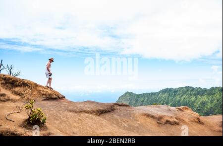 Un touriste marchant sur le sentier surplombant la vallée de Kalalau sur la côte de Na Pali, Kauai, Hawaï, États-Unis. Cette section du sentier s'érode de de plus de u Banque D'Images