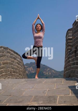 Femme pratiquant le yoga sur la Grande Muraille de Chine Banque D'Images