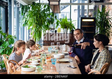 Une famille de quatre personnes ayant un dîner dans un café. Banque D'Images