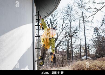 un jeune garçon escalade une tour d'eau en hiver Banque D'Images