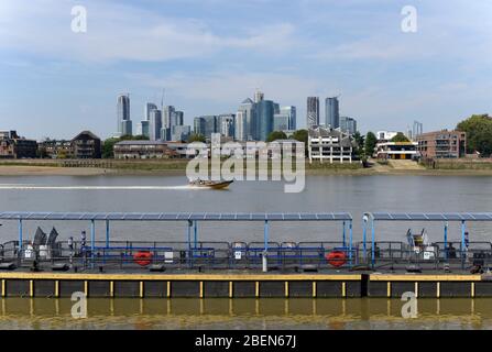 Un bateau passe devant le quai du ferry sur la Tamise à Greenwich, Londres, Royaume-Uni Banque D'Images