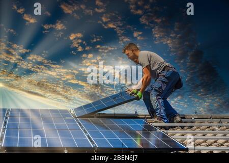 Portrait des travailleurs qui installent des panneaux photovoltaïques sur le toit Banque D'Images