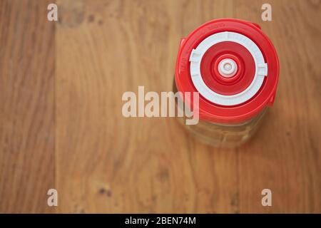 Une prise en charge d'un pot en verre contenant du kéfir d'eau et scellé avec un couvercle de fermentation rouge vif indiquant la date actuelle. Concept de santé l Banque D'Images