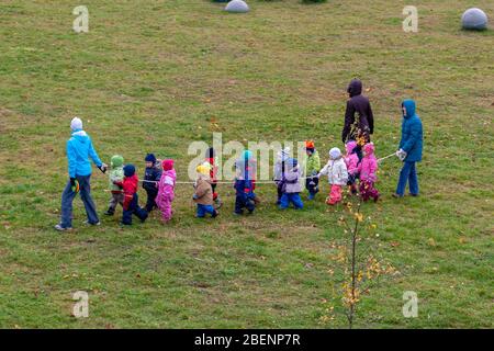 Tallinn, Estonie - 29 octobre 2008: Les enfants de la maternelle se tiennent sur la corde. Ils marchent dans le parc avec les enseignants. Fin de l'automne. Habillés Banque D'Images