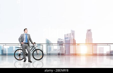 Jeune homme debout sur le balcon avec le vélo Banque D'Images