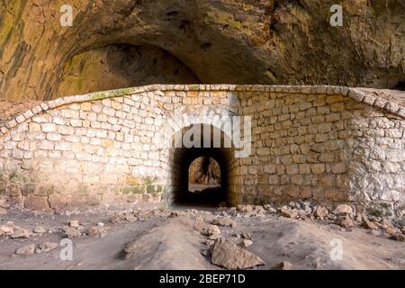 Bulgarie. Vieux murs en pierre avec arche dans la grotte de Devetaki Banque D'Images