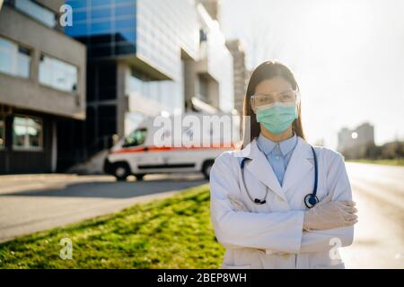 Brave coronavirus paramédical devant l'établissement hospitalier d'isolement.Covid-19 médecin de salle d'urgence avec lunettes de protection / masque de triage pour Banque D'Images