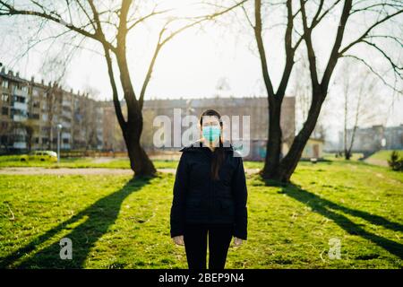 Personne déprimée effrayée portant un masque pour prévenir la propagation de la maladie au printemps nature.pandémie de coronavirus vie terne.panique et peur.ef émotive Banque D'Images