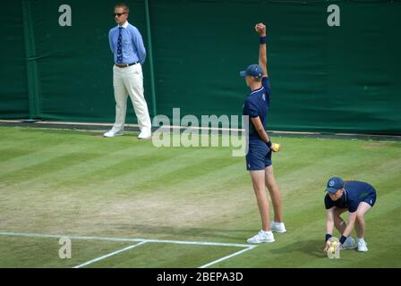 Des garçons de balle pour Andy Murray et Serena Williams jouant contre Bruno Soares et Nicole Melichar, 2019 championnats de Wimbledon, Londres, GB. Banque D'Images