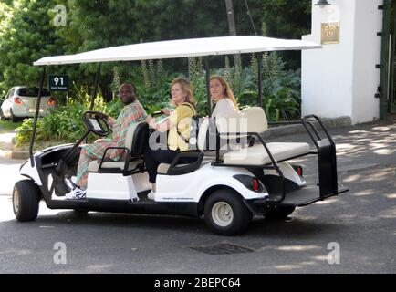 Deux femmes se promonent sur le terrain d'un hôtel de luxe du Cap. Ils sont sur une voiturette électrique ou un buggy et conduits par un membre du personnel. En tant que touristes, ils apprécient le luxe de la promenade dans la chaleur de l'après-midi. Banque D'Images