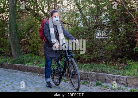 Leipzig. 1 avril 2020. Photo symbolique sur le sujet de la pandémie de corona, Covid-19 - une femme porte un respirateur FFP2 et se tient dans la rue à vélo, prise le 1 avril 2020 à Leipzig. A créé la photo symbolique. | utilisation dans le monde crédit: dpa/Alay Live News Banque D'Images