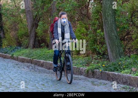 Leipzig. 1 avril 2020. Photo symbolique sur le sujet de la pandémie de corona, Covid-19 - une femme porte un respirateur FFP2 et est en vélo dans la rue, prise le 1 avril 2020 à Leipzig. A créé la photo symbolique. | utilisation dans le monde crédit: dpa/Alay Live News Banque D'Images