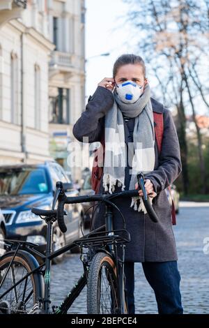 Leipzig. 1 avril 2020. Photo symbolique sur le sujet de la pandémie de corona, Covid-19 - une femme porte un respirateur FFP2 et se tient dans la rue à vélo, prise le 1 avril 2020 à Leipzig. A créé la photo symbolique. | utilisation dans le monde crédit: dpa/Alay Live News Banque D'Images