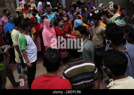 Dhaka, Bangladesh. 15 avril 2020. Les travailleurs du vêtement prêts à l'emploi donnent une interview à la télévision, car ils exigent un salaire devant une usine de vêtements lors du verrouillage imposé par le gouvernement à Dhaka. Crédit: MD Mehedi Hasan/ZUMA Wire/Alay Live News Banque D'Images