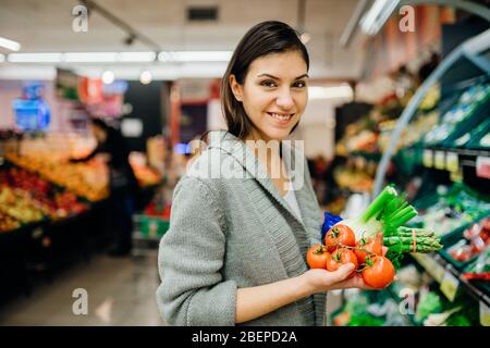 Jeunes femmes shopping dans le supermarché épicerie.Achat de légumes biologiques durable produits.Source naturelle de vitamines et minéraux.Vegan/vege Banque D'Images