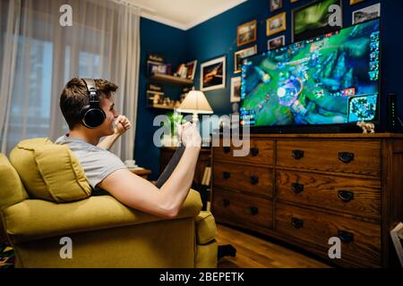 Jeune joueur esport professionnel avec casque jouant et gagnant de la compétition Internet MMORPG cyber championnat dans la stratégie de tir de première personne sur Banque D'Images
