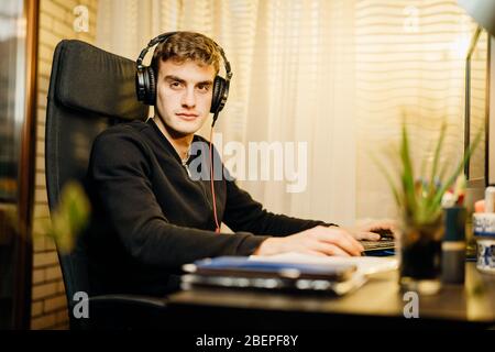 Joueur esport professionnel avec casque jouant à Internet compétitif MMORPG cyber tournoi dans la stratégie de tir de première personne jeu vidéo en ligne sur h Banque D'Images
