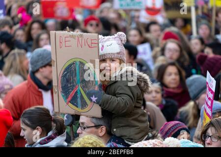 Jeune fille assise sur les épaules d'un homme et tenant une lecture de signe "Be Nice", à la Marche des femmes 2017, Londres Banque D'Images