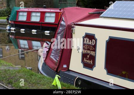 Canaux bateaux étroits (arc de 1 bateau) amarrés, réflexions, eau, panneau solaire, corde d'amarrage, couverture - Canal Leeds-Liverpool, Skipton, Yorkshire Angleterre Royaume-Uni Banque D'Images