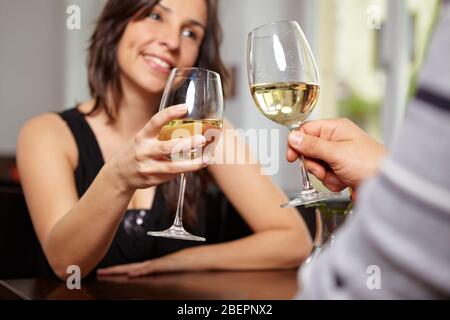 Couple toasts avec vin blanc dans le restaurant Banque D'Images
