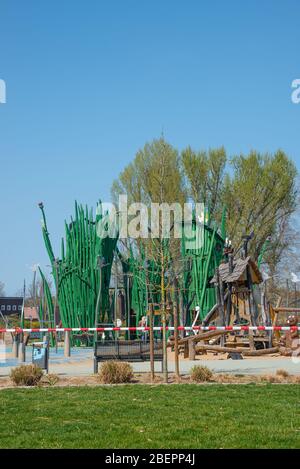 Aire de jeux moderne en plein air pour les enfants dans le parc municipal de Magdeburg fermée en raison de l'épidémie de coronavirus dans le monde entier et en Allemagne, début du printemps Banque D'Images