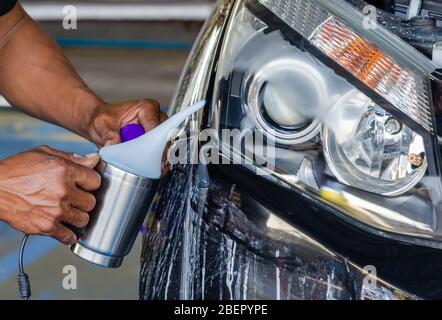 Après avoir polir la lampe frontale de la voiture. Revêtement vernis de phare. Banque D'Images