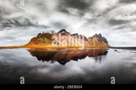 Paysage incroyable des célèbres montagnes Stokksnes sur le cap de Vestrahorn. Réflexion dans l'eau claire sur le ciel épique, l'Islande Banque D'Images