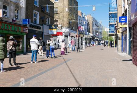 Documenter les jours de virus Corona à Londres pendant la période de restriction de verrouillage. Hackney central poste file d'attente, Londres, 14/04/2020 Banque D'Images