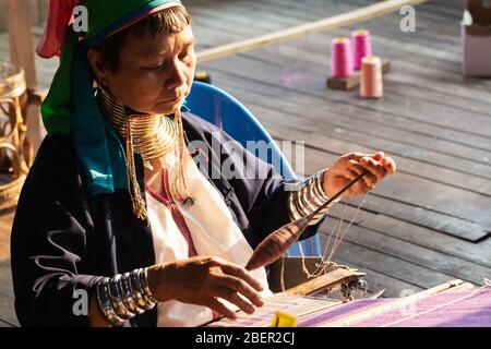 Inle, Myanmar - Mars 2019 : Kayan Lahwi tribu long cou femme assise derrière le métier à tisser dans une boutique touristique sur le lac Inle Banque D'Images