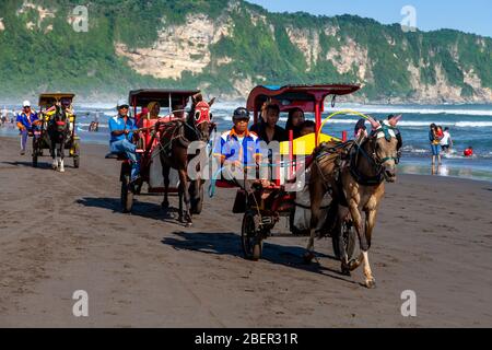 Les Indonésiens qui apprécient les promenades en chevaux et en calèche sur la plage de Parangtritis, Yogyakarta, Indonésie. Banque D'Images