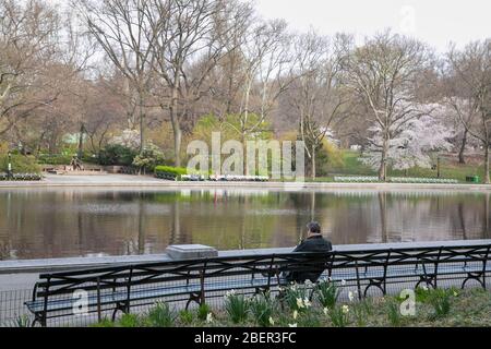 Un homme assis sur un banc à Central Park, New York. Banque D'Images