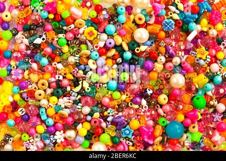 Arrière-plan de perles multicolores. Mélange de verre brillant de différentes tailles, forme bijoux et perles en plastique. Banque D'Images