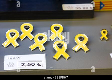 Gérone, Espagne - 24 février 2020: Ruban jaune symbole de l'indépendance de la Catalogne. Badges métalliques de taille différente dans la fenêtre du magasin. L'indépendance catalane Banque D'Images