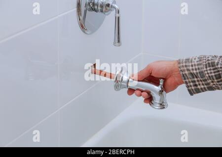 Plombier installant robinet d'eau dans la salle de bains avec Banque D'Images