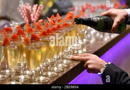 Des coupes de champagne sont remplies lors d'un événement d'accueil d'entreprise à Birmingham, en Angleterre, au Royaume-Uni Banque D'Images