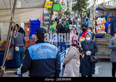 14 avril 2020: Les agents municipaux de Zeytinburnu donnent un masque médical pour empêcher les gens de coronavirus sur le marché de la rue le 14 avril 2020, dans le district de Zeytinburnu, Istanbul, Turquie. Le 27 mars 2020, le Ministère de l'intérieur a publié une circulaire supplémentaire sur les marchés dans le cadre de la lutte contre l'épidémie de coronavirus. Par conséquent, la vente de fournitures non essentielles autres que les aliments de base et les agents de nettoyage ne sera pas autorisée. Les municipalités prennent les mesures nécessaires en matière d'hygiène et de désinfection sur les marchés. (Image crédit : © Tolga Ildun/ZUMA Wire) Banque D'Images