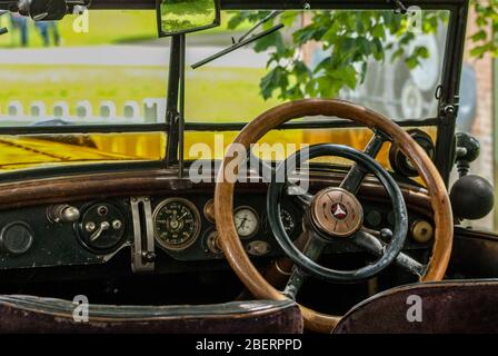 Vue depuis le siège arrière d'une voiture Vintage. Volant, tableau de bord et instruments en bois. Banque D'Images