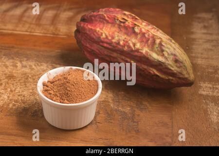 Pile de poudre de cacao sur une table en bois Banque D'Images